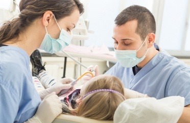 Licensed dental assistant and dentist treating patient