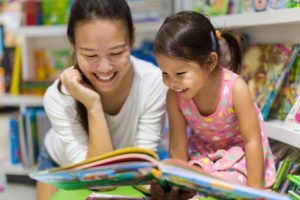 Mom and daughter reading about dental assistant school for moms