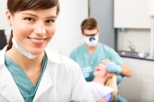a dental assistant smiling while assisting a patient