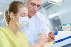 a dental assistant being instructed by her teacher