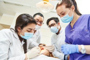 a group of dental assistant students helping a patient