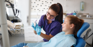 a dental assistant helping a young patient 