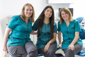 a trio of dental assistants smiling 